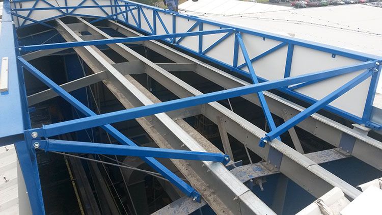 Modrý ocelový rám nad otvorem ve střeše