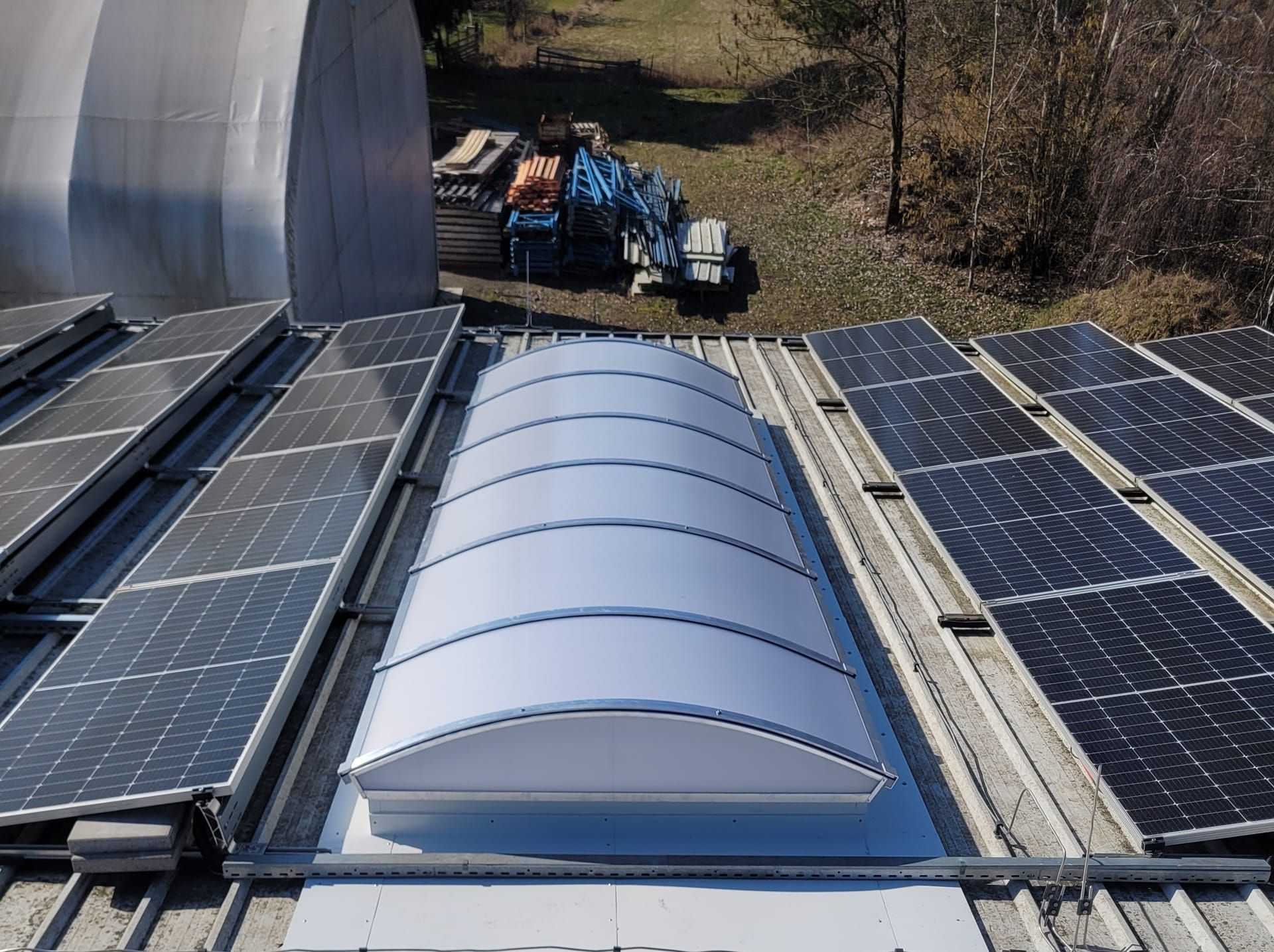 Obloukový světlík na střeše mezi fotovoltaickými panely