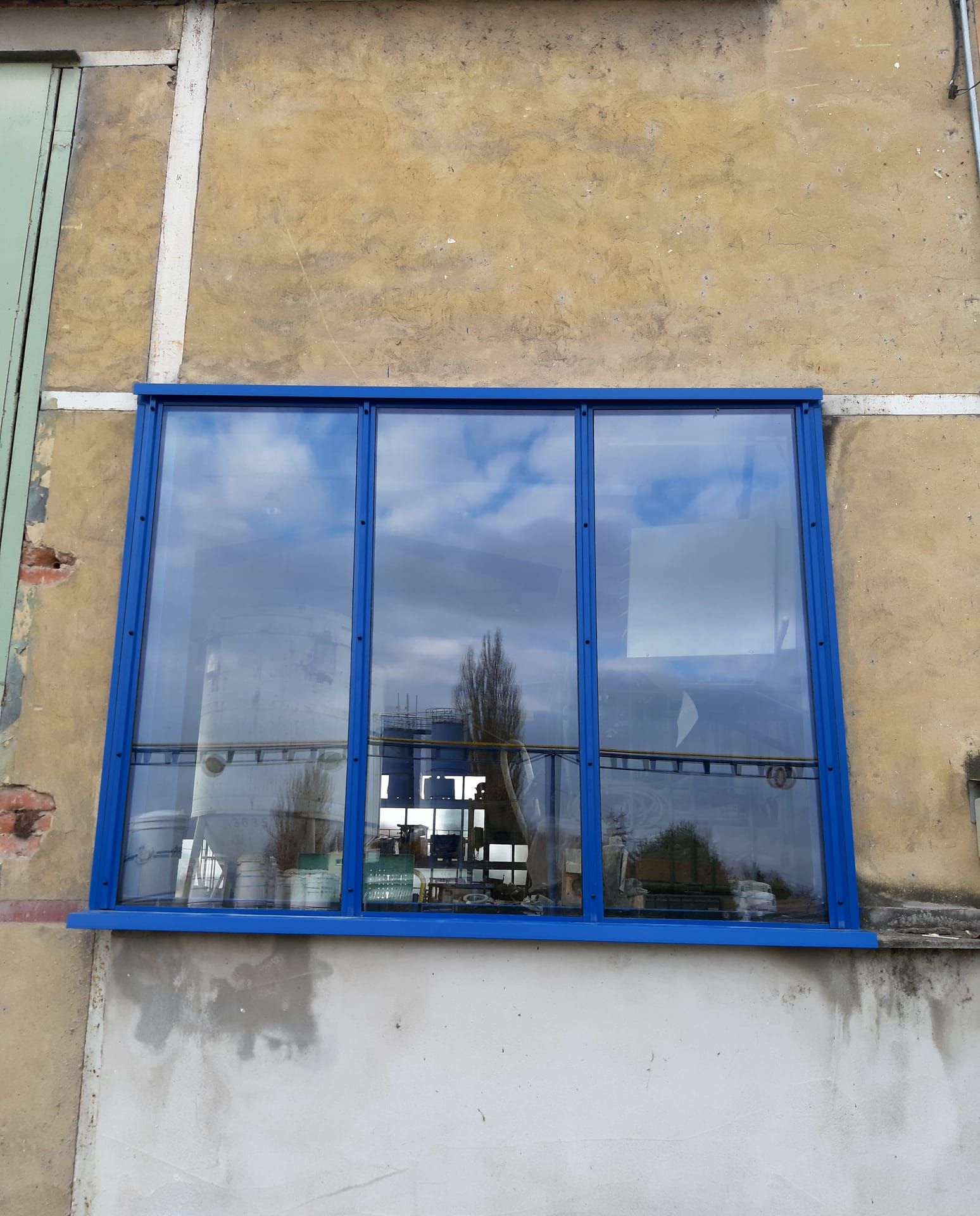 Detail nového třídílného zasklení v modrém rámu